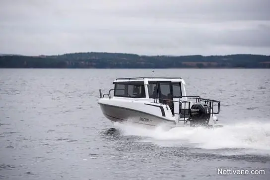 A white motorboat named "Falcon 17" speeds across a calm lake under a cloudy sky.